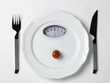 Dish with a tomato and a dial of a bathroom scale