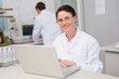 © WavebreakMediaMicro - Smiling scientist using laptop