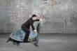 Businessman riding turtle and indicating with finger in concrete