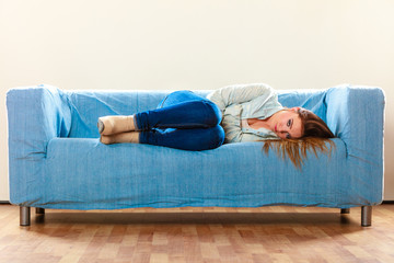 Sad woman laying on couch