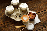 Fototapeta Mapy - Paper cups of coffee latte and cake on wooden background