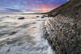 Fototapeta Fototapety z morzem do Twojej sypialni - Dynamiczny wschód słońca nad skalistym wybrzeżem morskim