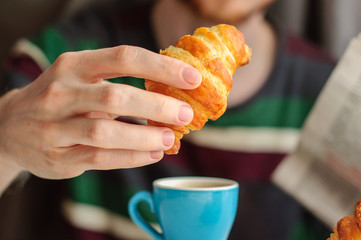 Breakfast with coffee and croissant with young man on backgroung