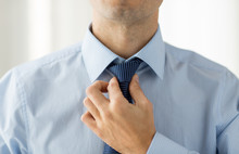 Close Up Of Man In Shirt Adjusting Tie On Neck