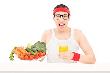 Wall Mural - Nerdy young guy holding a glass of orange juice