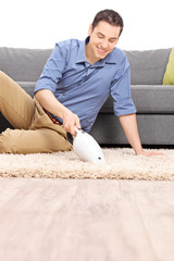 Poster - Man cleaning carpet with a handheld vacuum cleaner