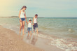 © Malsveta - Mother and her two sons having fun on the beach