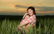 © soleg - happy mother and child in green field at sunset