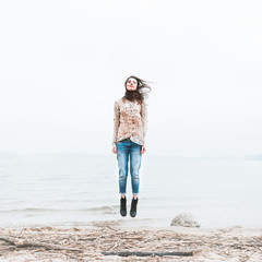 happy young woman on a coast on a windy day