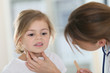 © goodluz - Pediatrician in office checking on child's throat