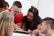 © photoniko - group of students in a bright room on the bed watching something