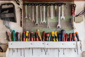 Vintage Tools Hanging On A Wall In A Garage Or Workshop
