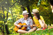 © Zoran Zeremski - Young couple in love playing acoustic guitar in the park
