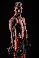 Wall Mural - muscular young man lifting weights on dark background