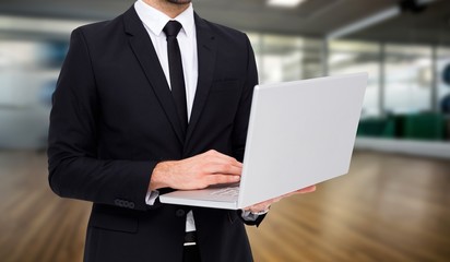 Poster - Composite image of mid section of a businessman using laptop