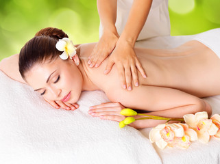 Woman having massage of body in nature spa