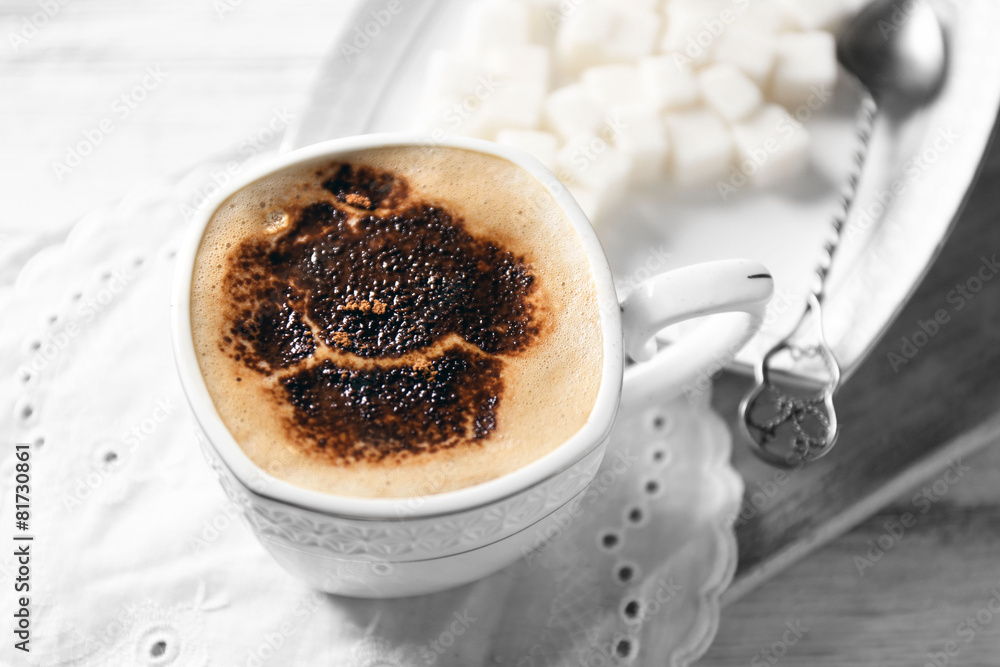 Cup of latte coffee art on wooden table, on light background