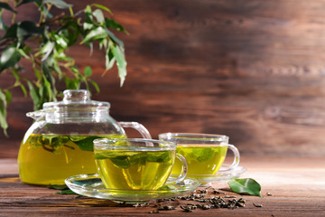 Wall Mural - Cups of green tea on table on wooden background