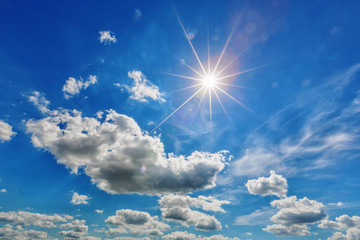 white clouds with sun in blue sky