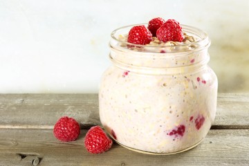 Wall Mural - overnight breakfast oats with raspberries in a mason jar on wood