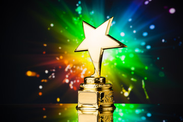 Wall Mural - gold star trophy against rainbow sparks background
