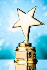 Wall Mural - gold star trophy against blue sparks background