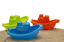 Three Plastic Toy Boat On Sand Isolated On White