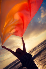 Sticker - Silhouette of young woman jumping at the beach