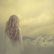 © VectorART - girl in a dress stands in the clouds over the mountains