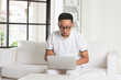© wong yu liang - Southeast Asian male using internet at home, sitting on sofa sho
