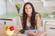 © WavebreakmediaMicro - Pretty brunette using tablet pc and preparing salad