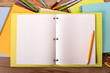 © david_franklin - Student desk with open book or yellow project folder ready for writing homework essay exam college study pens and pencils in the background photo