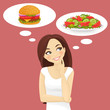 Beautiful woman choosing between salad and hamburger