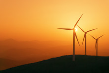 Wind Turbines Silhouette On Mountain At Sunset