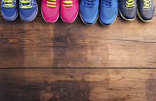 Various Running Shoes Laid On A Wooden Floor Background