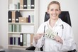 © Sebastian Gauert - Close up Happy Woman Doctor Holding US Dollars