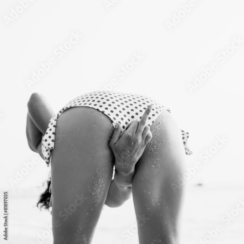 Fototapeta na wymiar Young woman standing on beach and looking to sea