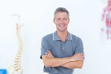 Smiling doctor standing arms crossed