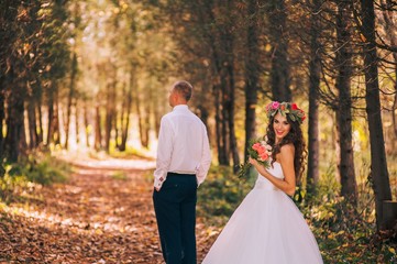 happy bride and groom walking in the autumn forest