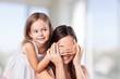 © BillionPhotos.com - Background. Young daughter closes hands eyes mom - isolated