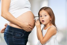 Pregnant. Kid Girl Listening With Can Pregnant Mother's Stomach