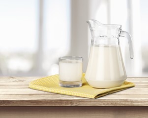 Wall Mural - Milk. A glass of milk and a milk jug on plaid tablecloth.