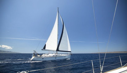 Ship yachts with white sails in the open Sea. Luxury boats.