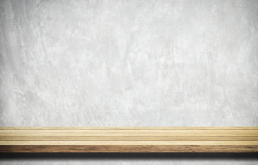 Empty wooden table over white cement wall.