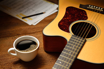 Wall Mural - Cup of coffee and guitar on wooden table