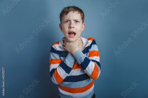 Fotografie, Obraz European-looking boy of ten years strangles himself hands on a g
