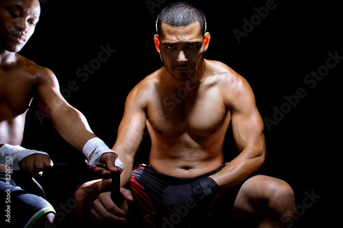 Fotografering Latin MMA fighter or Boxer with trainer applying athletic tape