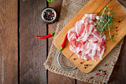 Fototapeta na szkło Slices of bacon on the wooden background