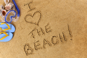 Love word text message written in sand on a tropical beach with seashells and accessories holiday vacation photo