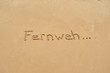German word 'Fernweh' in the sand